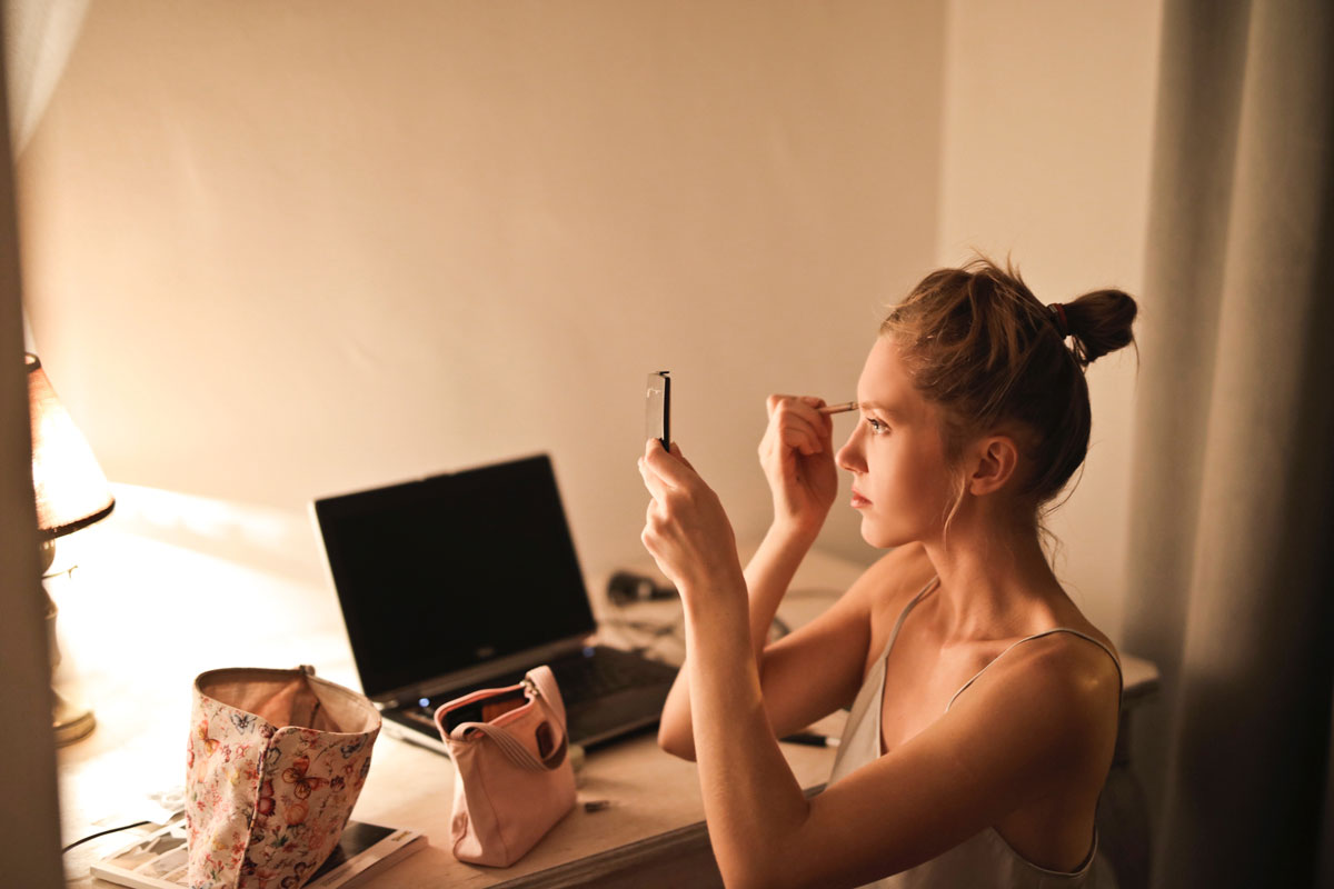 A photo of a woman applying makeup